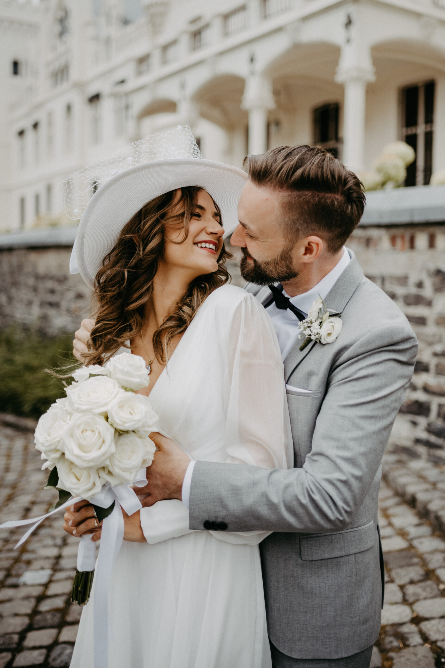 Brautpaar umarmt sich vor dem Schlosshotel Kommende in Ramersdorf Bonn. Fotografiert von Hochzeitsfotografin Daria Lanzet