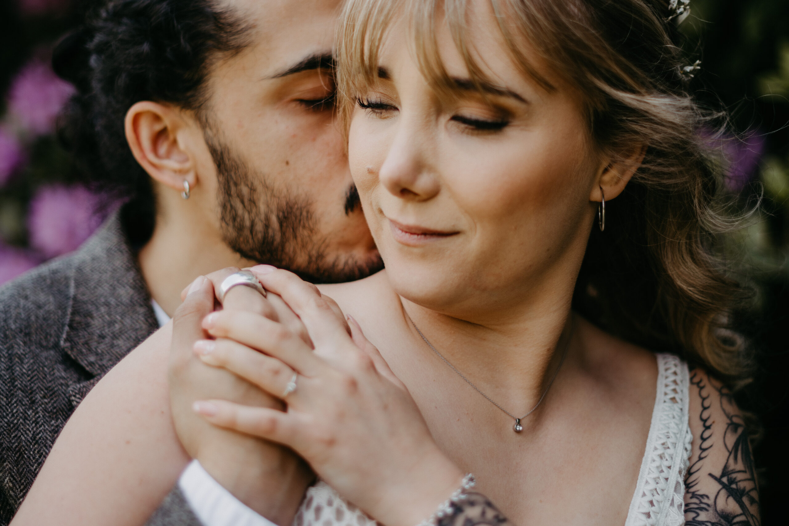 Bräutigam umarmt Braut beim Brautpaarshooting von hinten. Sie haben die Augen geschlossen und genießen den innigen Moment. Fotografiert von Daria Lanzet