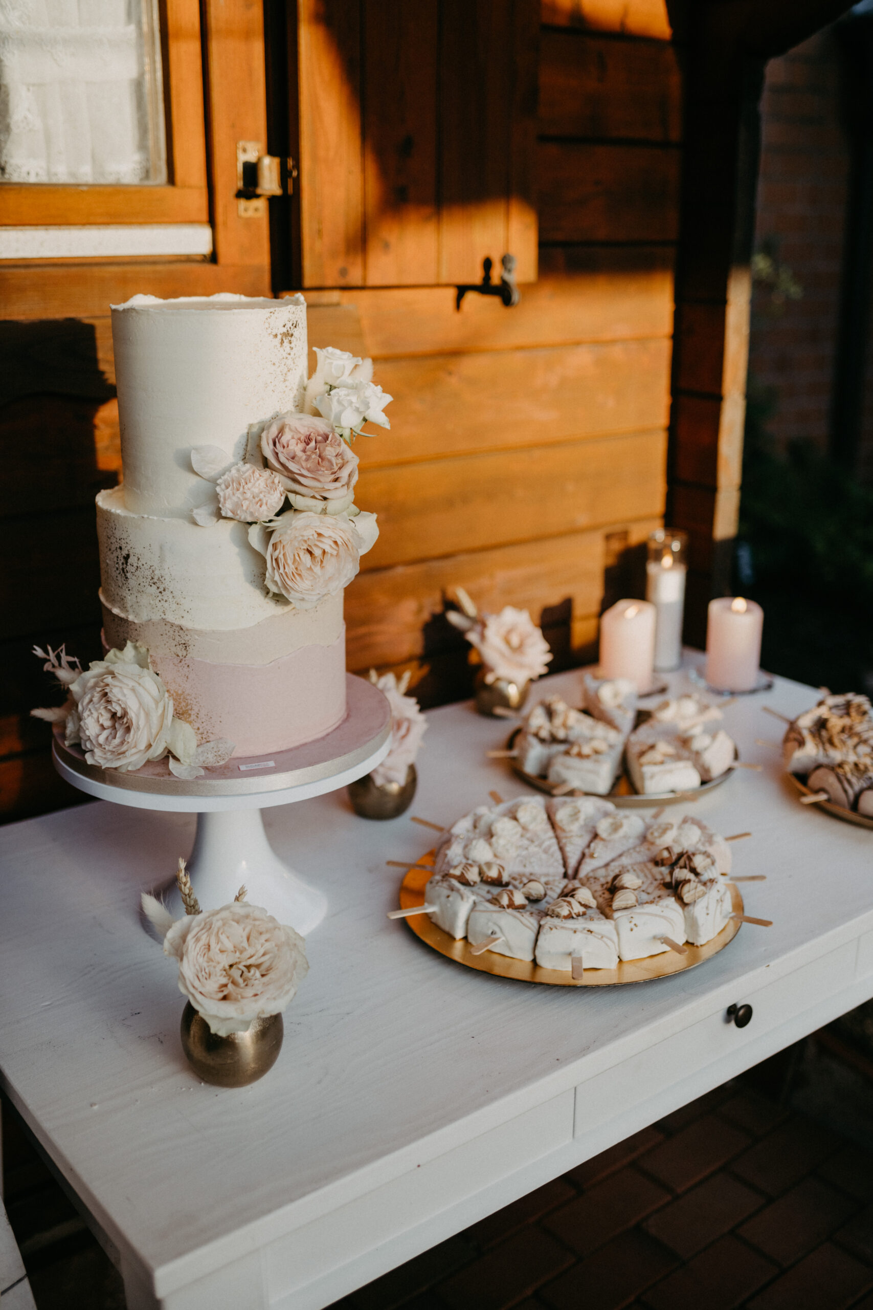 Sweet Table, Hochzeitstorte in weiß und rose mit Blumen, neben Cheese Cake und Cake Pops auf einer Hochzeit von Zuckersüß und lecker Brot, Fotografin Daria Lanzet