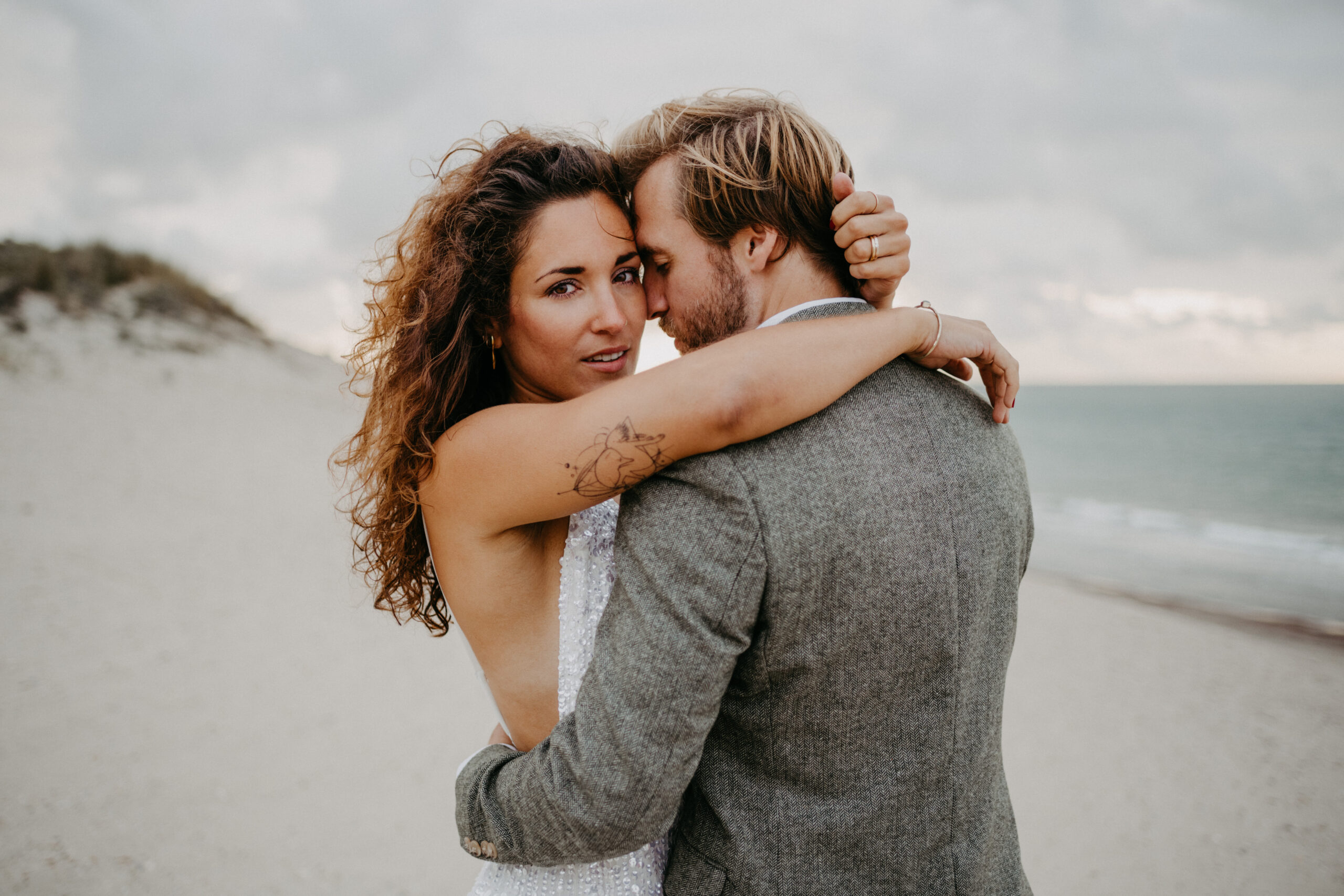 Brautpaar läuft Hand in Hand beim Brautpaarshootung in Holland am Strand von Renesse, fotografiert von Daria Lanzet