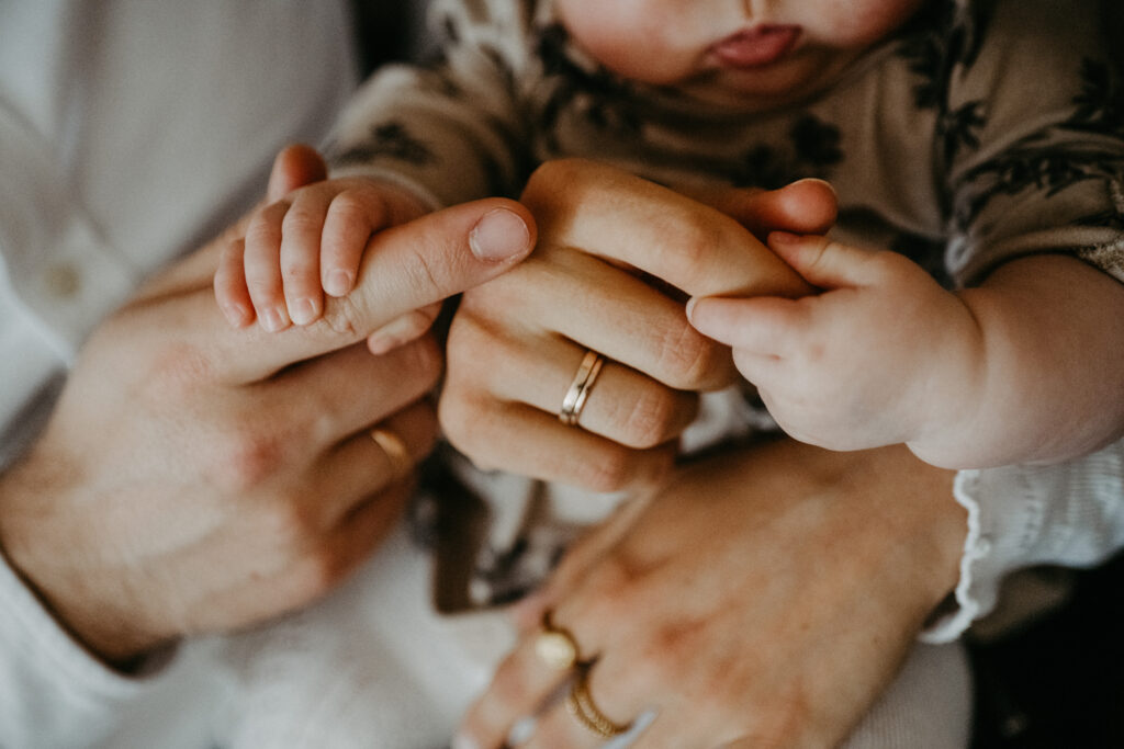 Detailfoto von Babyhänden beim Babyfotoshooting in Essen