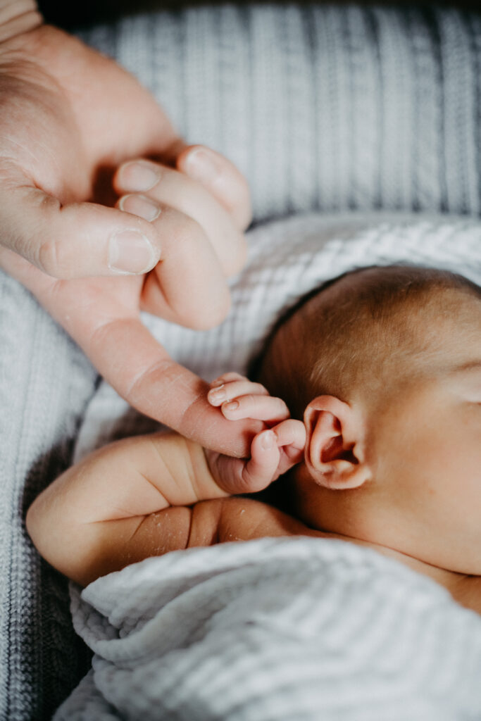 Detailfoto von Babyhänden und Ohren beim Babyfotoshooting in Essen