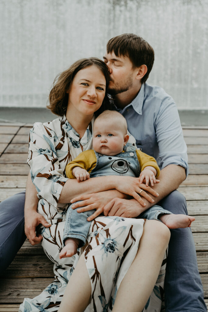 Familie mit Baby sitzt zusammengenuschelt beim Fotoshootings in Bonn